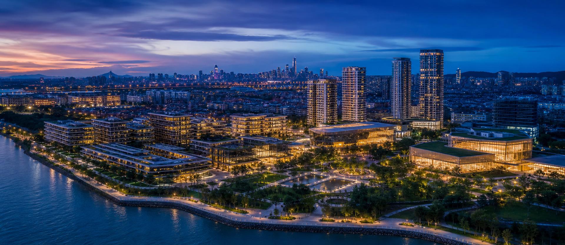 Aerial view of a large-scale waterfront urban development at twilight